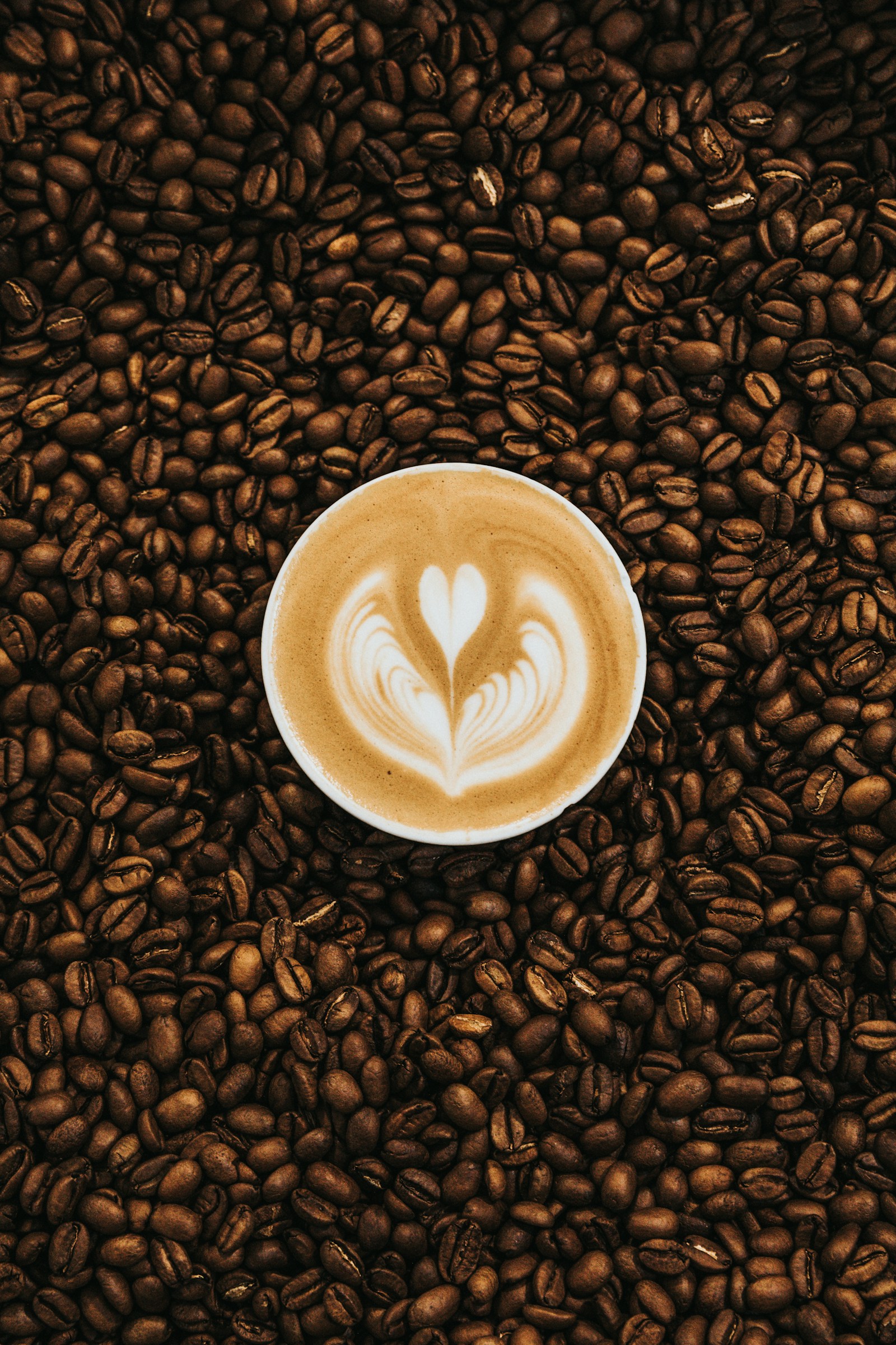 Latte art rodeado de granos de café
